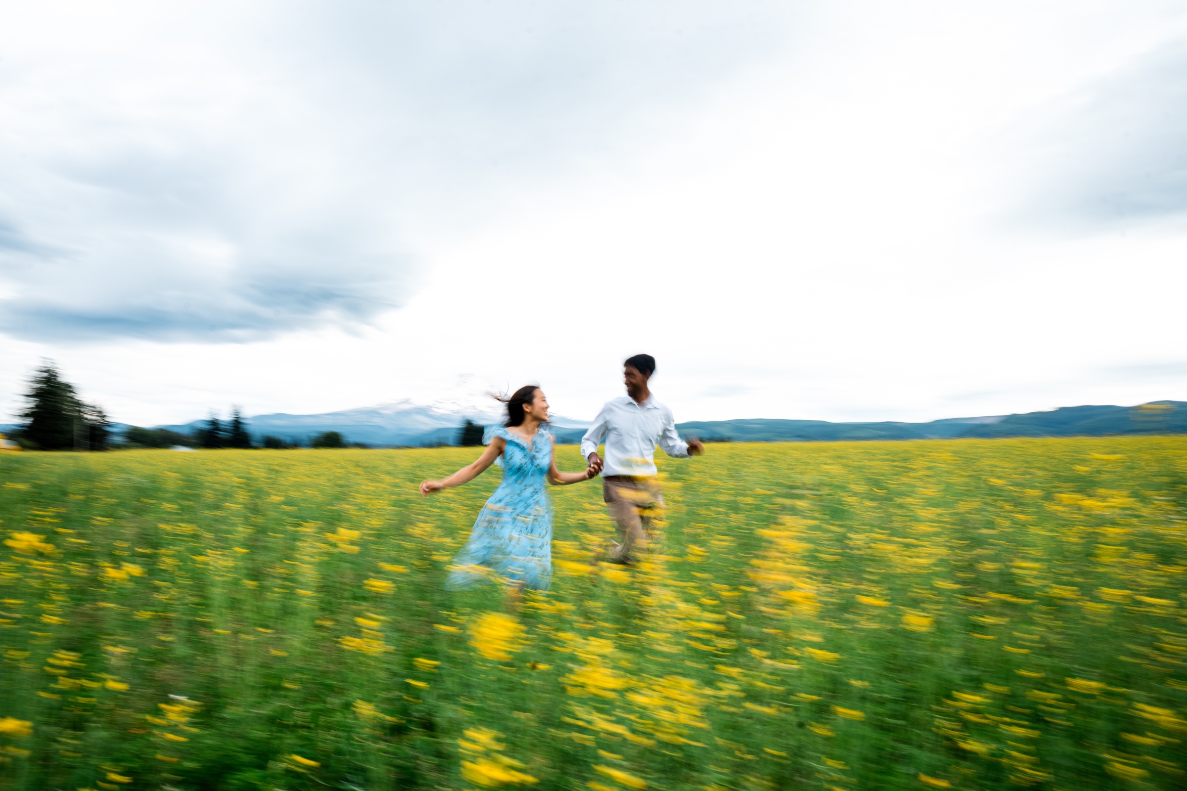 Elizabeth and Alvan holding hands and running through the flower field